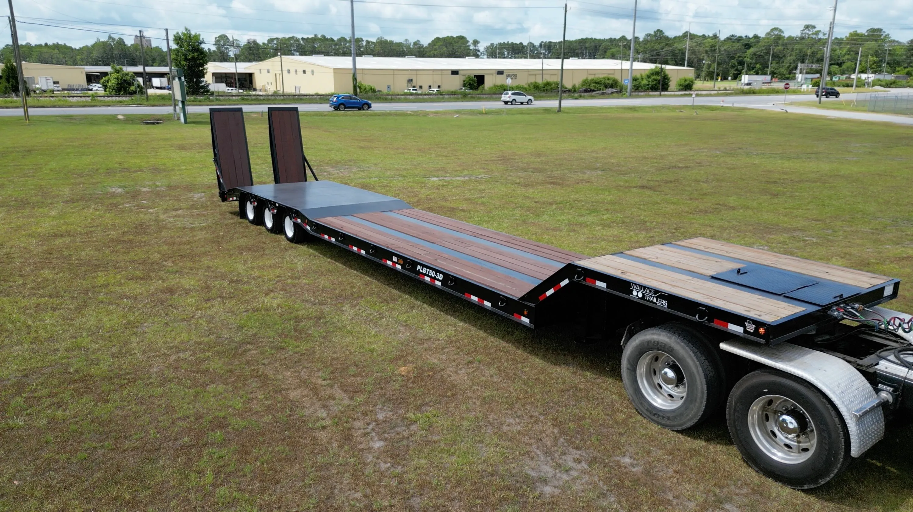Wallace lowboy trailer carrying heavy equipment